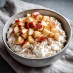 A bowl of Apple Cinnamon Cottage Cheese, topped with diced apples and a sprinkle of cinnamon.