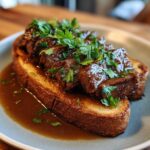 Close-up of Best Beef Manhattan featuring tender beef on toasted bread, topped with gravy and fresh parsley.