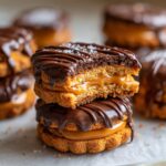 A stack of Buckeye Graham Crackers with a bite taken out, revealing the peanut butter filling and chocolate drizzle.