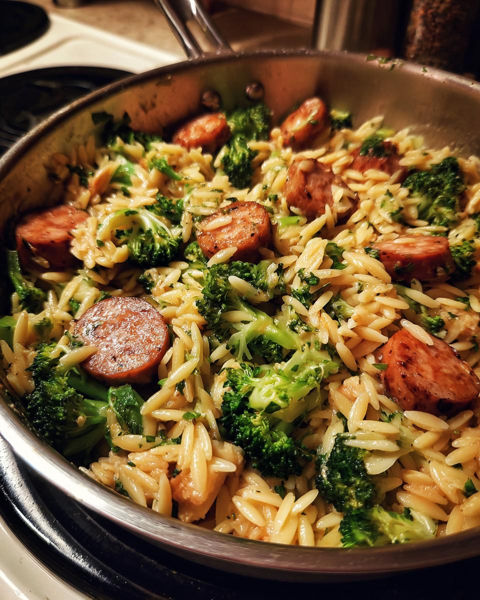 Chicken Sausage Broccoli Orzo in a stainless steel pan, ready to serve. 