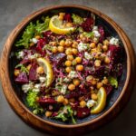 Overhead shot of a colorful Chickpea Beet Feta Salad with Lemon-Garlic dressing in a wooden bowl.
