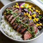 A delicious Cilantro Lime Steak Bowls with sliced steak, rice, beans, and corn.