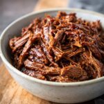 Close-up of tender Crockpot Garlic Butter Beef in a bowl, ready to serve.