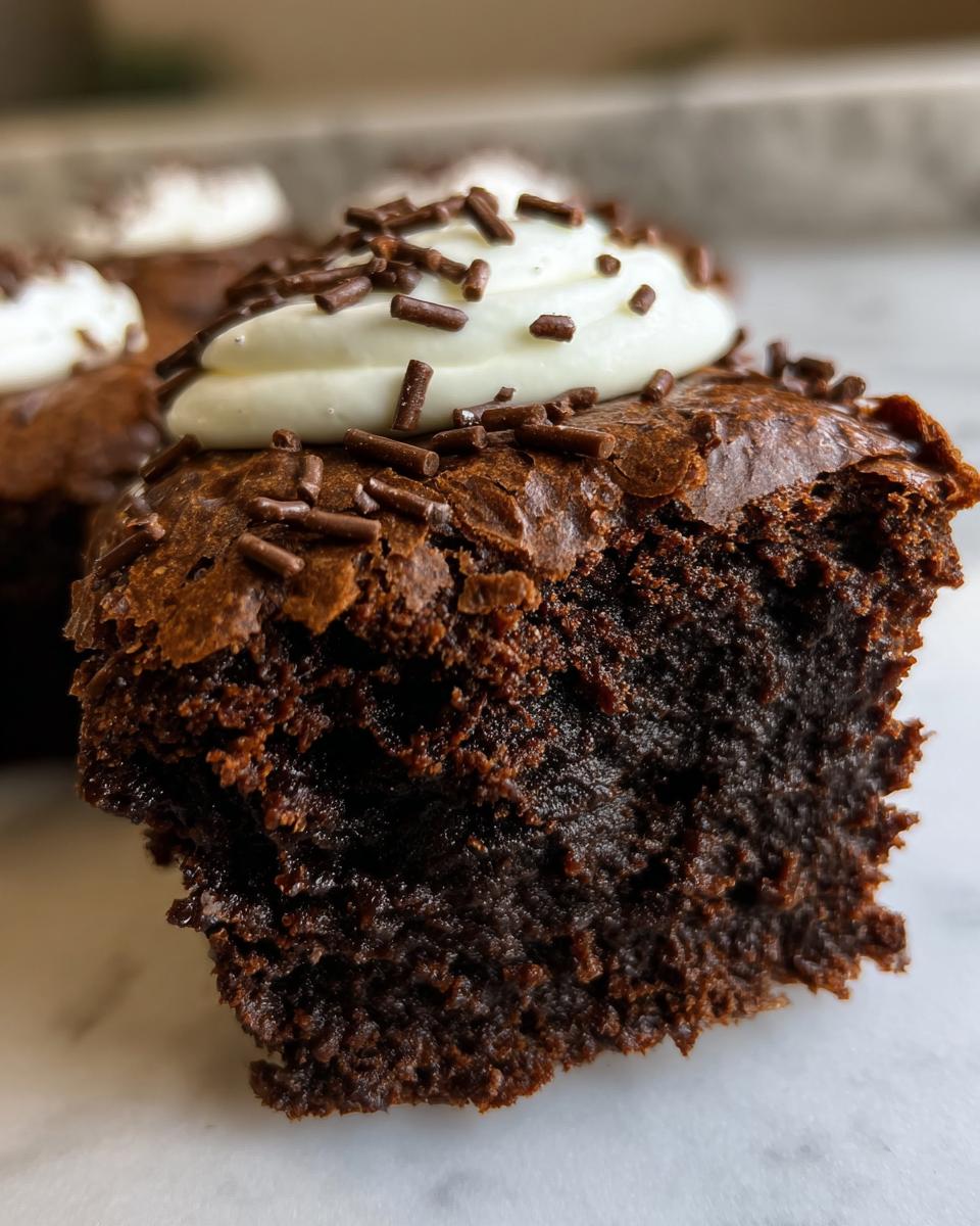 Close-up of a fudgy Protein Brownie topped with cream and chocolate sprinkles.
