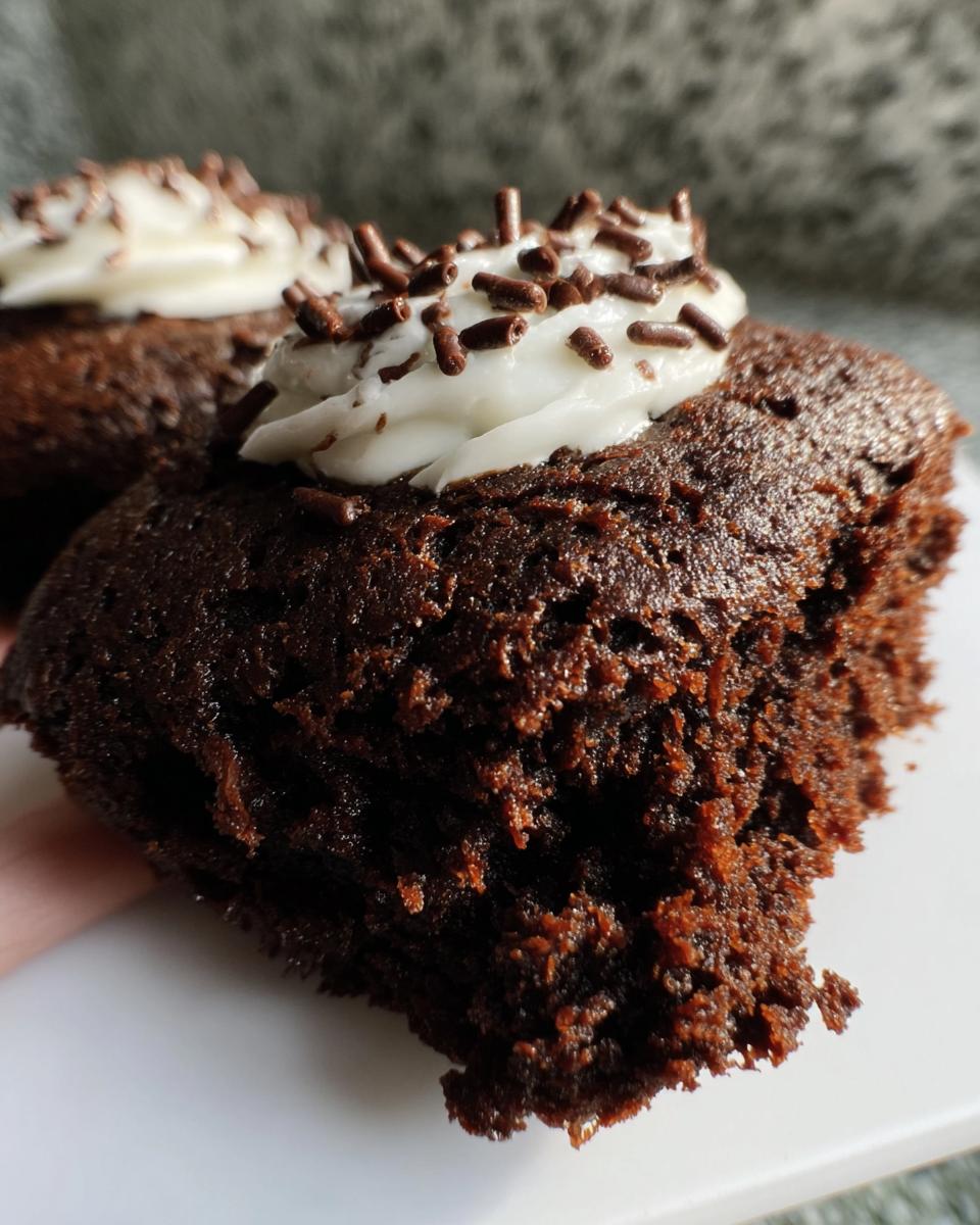Close-up of a fudgy Protein Brownie topped with white frosting and chocolate sprinkles.