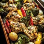 Overhead view of Garlic Butter Chicken Veggies on a baking sheet with broccoli, peppers, and onions.