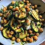 A vibrant bowl of Grilled Zucchini Chickpea Salad with fresh herbs and a creamy base.