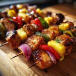 Close-up of Hawaiian Chicken Pineapple Kebabs with chicken, pineapple, peppers, and onions on skewers.
