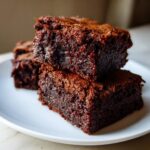 A stack of three delicious and fudgy Healthy 87 Calorie Brownies on a white plate.