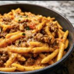 A bowl of delicious High Protein Beef Pasta, topped with cheese and herbs, ready to eat.