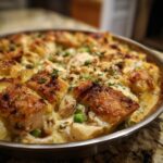 Close up of Ina Garten's Chicken Casserole Recipe, showing golden-brown topping, chicken, peas, and creamy sauce.