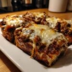 Close-up of Keto Philly Cheesesteak Rolls with melted cheese on a white plate.