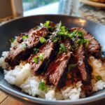 A delicious bowl of Korean BBQ Steak Rice, topped with green onions and sesame seeds.