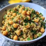 A bowl of Lemon Herb Quinoa Chickpeas, garnished with fresh herbs and red onion.