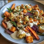 A plate of colorful Roasted Veggie, Tahini Yogurt, featuring cauliflower, sweet potatoes, and carrots drizzled with tahini yogurt.