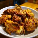 A bowl full of golden, fried Simple Crunchy Artichoke Hearts, ready to be served.