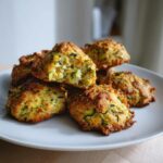 A plate of freshly baked Zucchini Cookies, one broken open to show the moist interior.