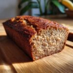 Close-up of a freshly baked 5-Ingredient Banana Bread loaf on a wooden cutting board.