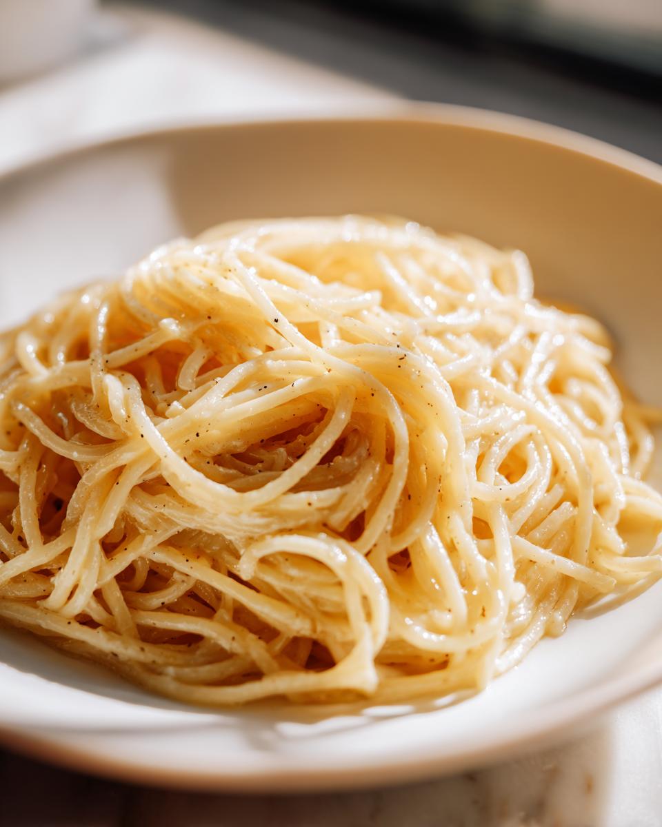 Close-up of Cacio e Pepe, a simple pasta recipe with spaghetti, cheese, and pepper.
