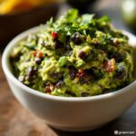 A bowl of creamy "Cauldron" Black Bean & Avocado Dip topped with fresh cilantro.