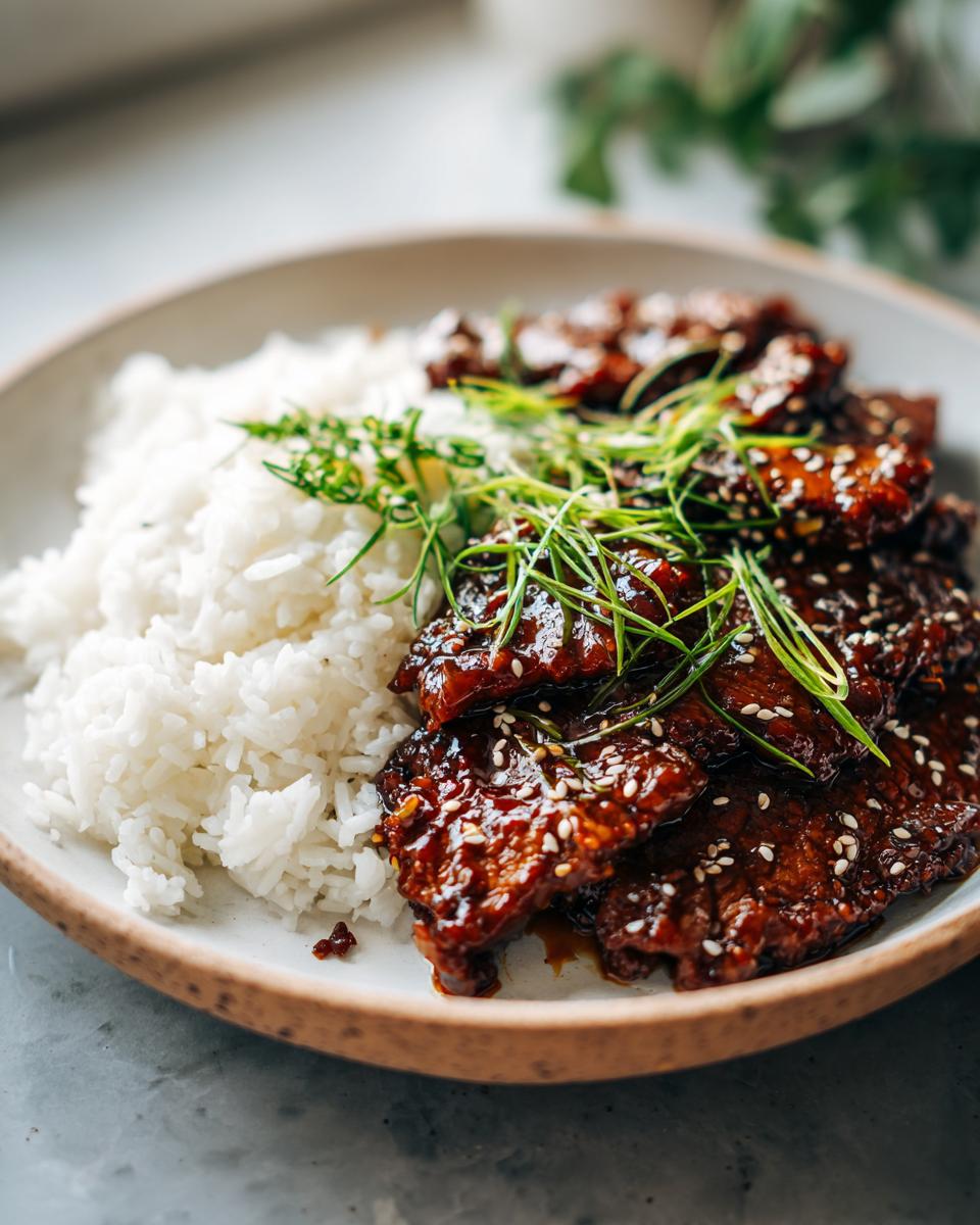 A plate of glazed pork with sesame seeds and rice, a delicious 5-Ingredient Easy Dinner recipe.