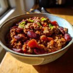 A bowl of hearty chili, a great Dinner Ideas Recipe Everyone Asks For, with ground meat, kidney beans, and vegetables.