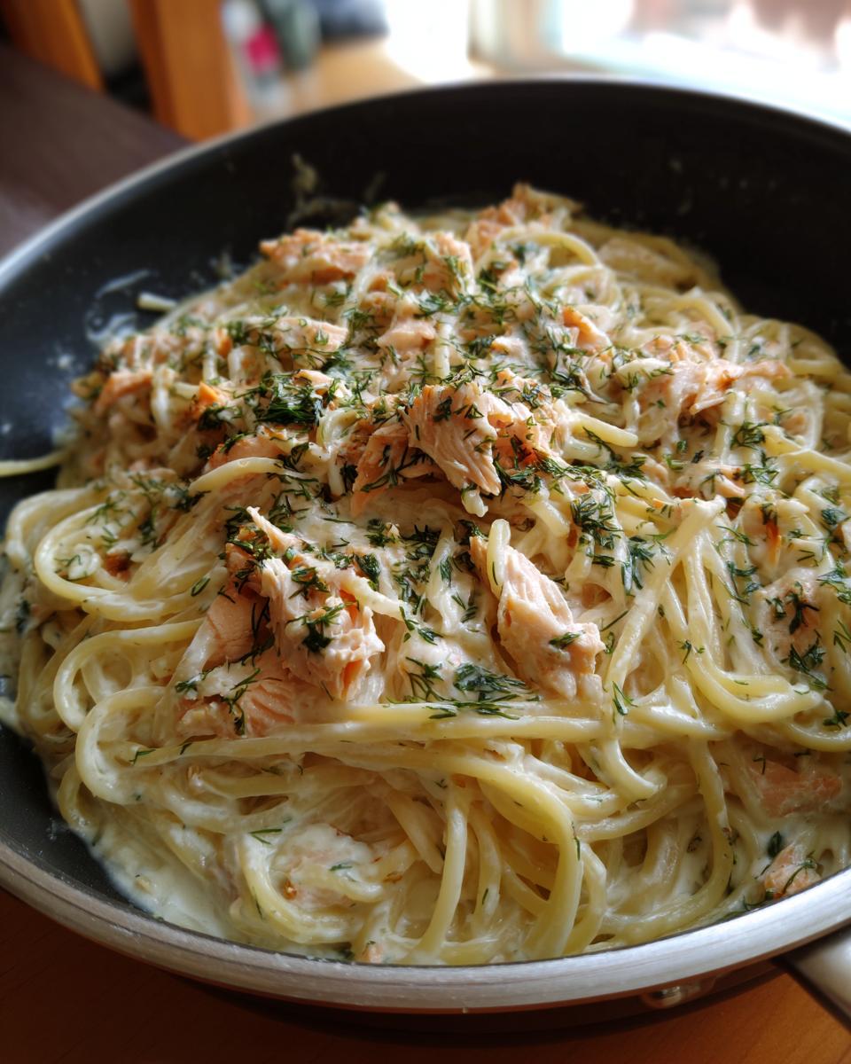 A pan filled with delicious Light & Creamy Salmon Pasta, garnished with fresh dill.