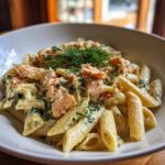 A bowl of Light & Creamy Salmon Pasta, garnished with fresh dill, showing the creamy sauce and salmon pieces.