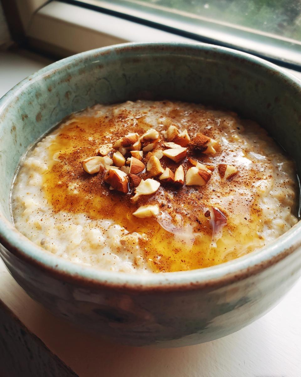 Bowl of oatmeal topped with honey and chopped almonds, a quick breakfast idea in 20 minutes.