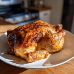 A perfectly roasted chicken with golden-brown skin, showcasing what makes perfect chicken.