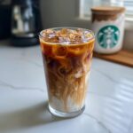 Iced coffee drink, showcasing what makes perfect Starbucks drinks with layers of coffee, milk, and ice in a tall glass.