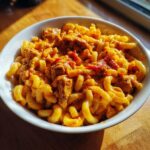 Bowl of Restaurant-Style Pasta Recipes at Home, featuring macaroni with a creamy sauce and chunks of meat.
