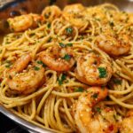 Close-up of Shrimp Scampi (Lighter) served with spaghetti, garnished with fresh parsley and spices.