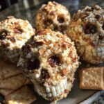 Three Skellington Cheese Ball Appetizer (2025) shaped like skulls, with crackers on a plate.