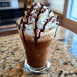 A decadent Starbucks Drinks in 20 Minutes style beverage with whipped cream, chocolate drizzle, and chocolate shavings.