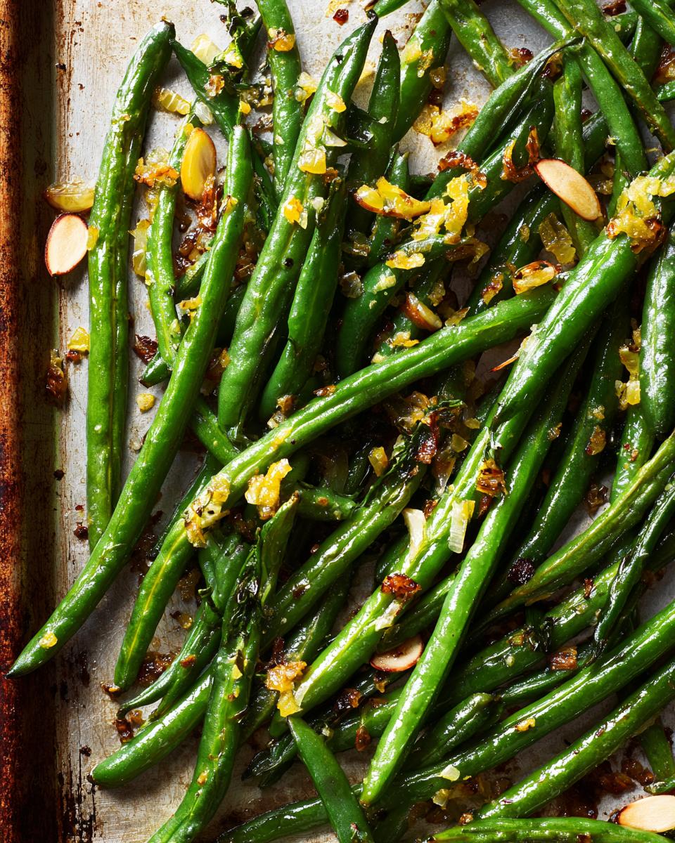 Overhead shot of Thanksgiving Green Beans with toasted almonds and citrus zest on a baking sheet.