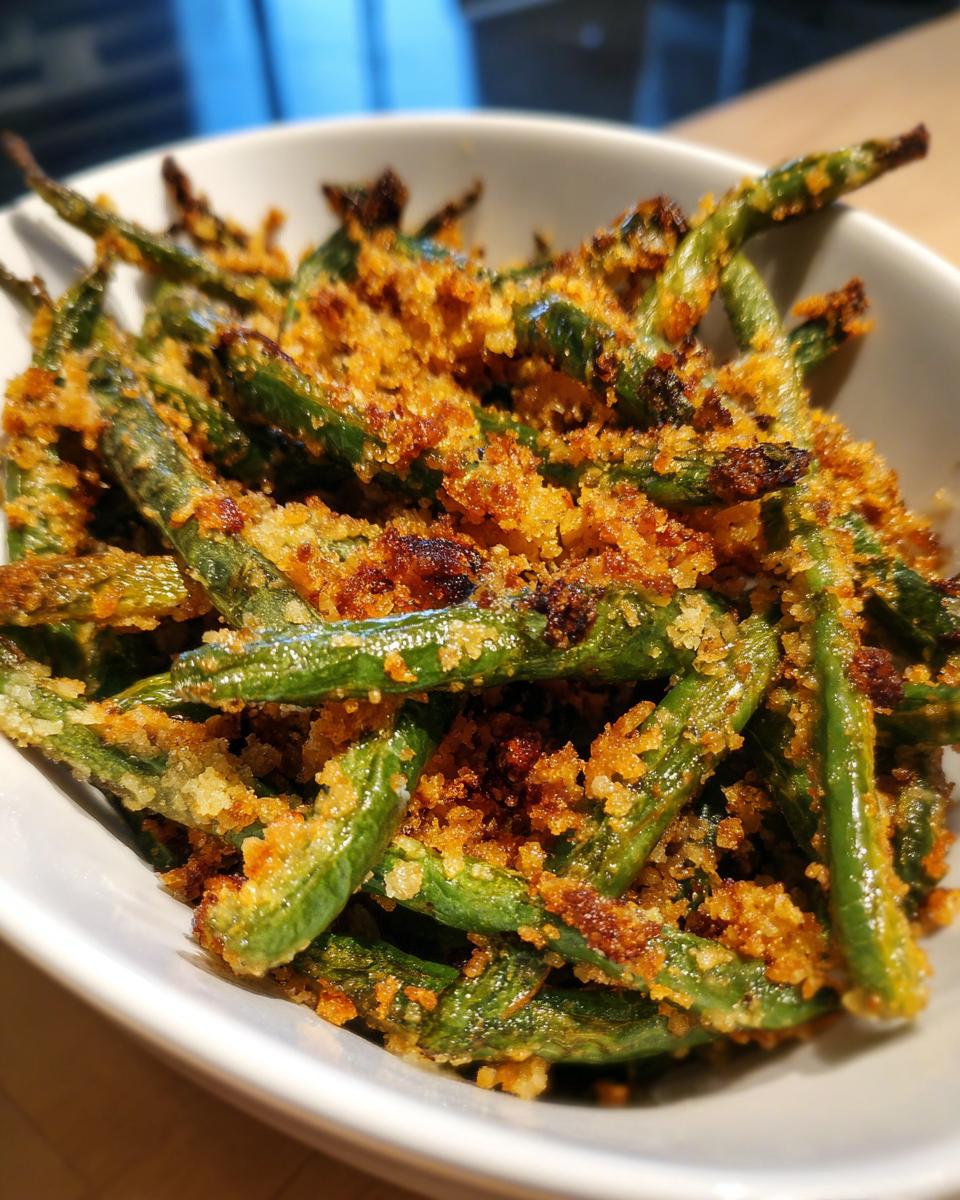 A bowl of Best Thanksgiving Green Beans 2025, featuring crispy, golden-brown breadcrumbs and vibrant green beans.