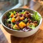 A vibrant Thanksgiving salad recipe featuring butternut squash, pecans, cranberries, and mixed greens.