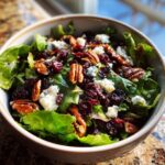 A delicious Thanksgiving Salad Recipe featuring cranberries, pecans, and blue cheese in a bowl.