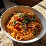 Bowl of spaghetti with tomato sauce and fresh basil. One of many easy Pasta Recipes in 20 Minutes.