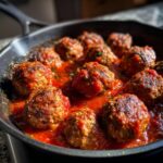 Delicious Turkey Meatballs In Marinara sauce simmering in a cast iron skillet, ready to serve.