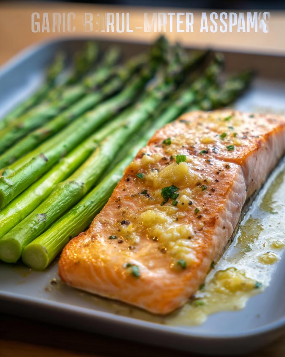 Close-up of a cooked salmon fillet topped with minced garlic butter next to bright green asparagus spears.