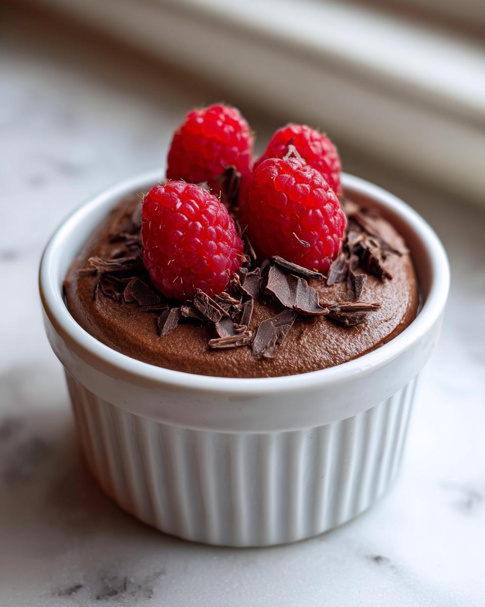 Rich chocolate mousse topped with fresh raspberries and chocolate shavings, perfect for Valentine’s Day Healthy Dessert Ideas.