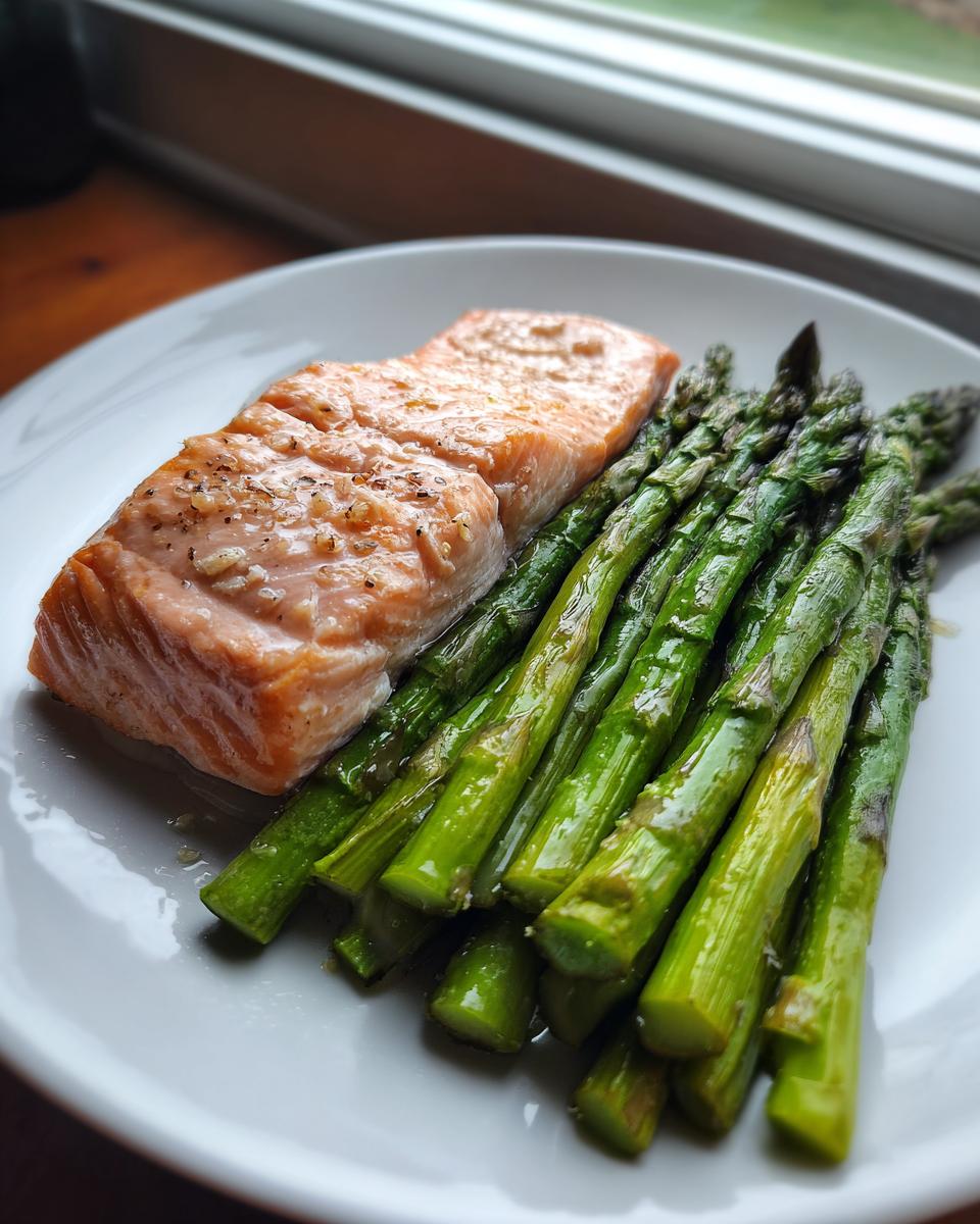A perfectly cooked salmon fillet served alongside bright green roasted asparagus, ideal for New Year Weight-Loss Dinner Ideas.