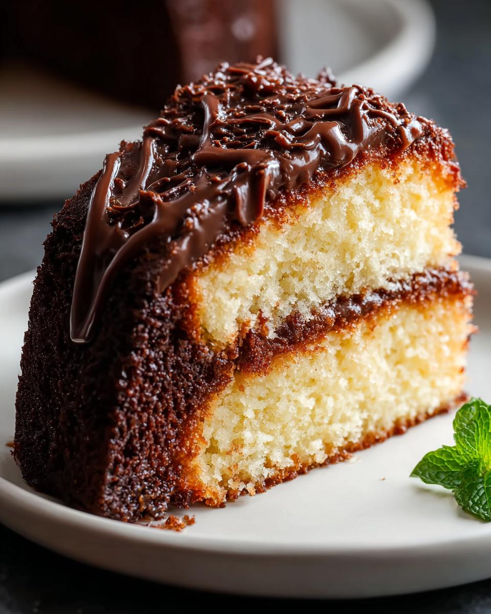 A moist slice of vanilla cake with chocolate filling and a rich chocolate glaze, part of The Ultimate Cake Ideas Recipes Guide for Beginners.