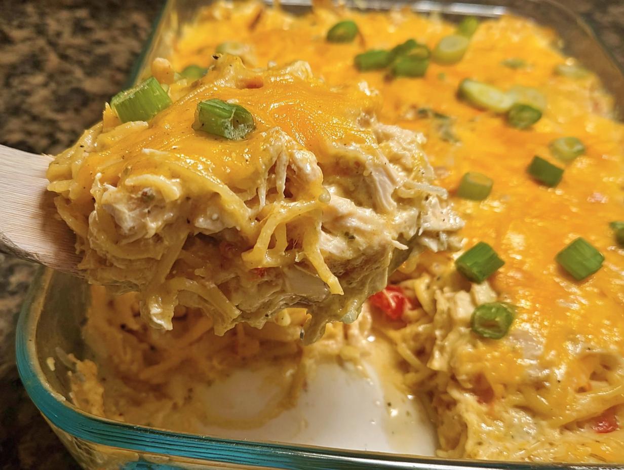 A spoonful of cheesy chicken spaghetti casserole being lifted from a glass dish, perfect for Healthy Family Dinners That Kids Enjoy.