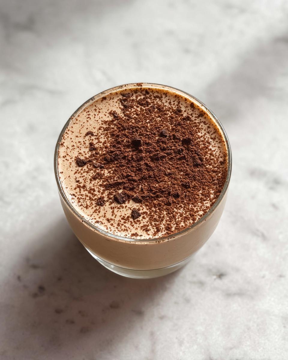 Overhead view of a glass containing finished Protein Coffee Jell topped with dark chocolate shavings.